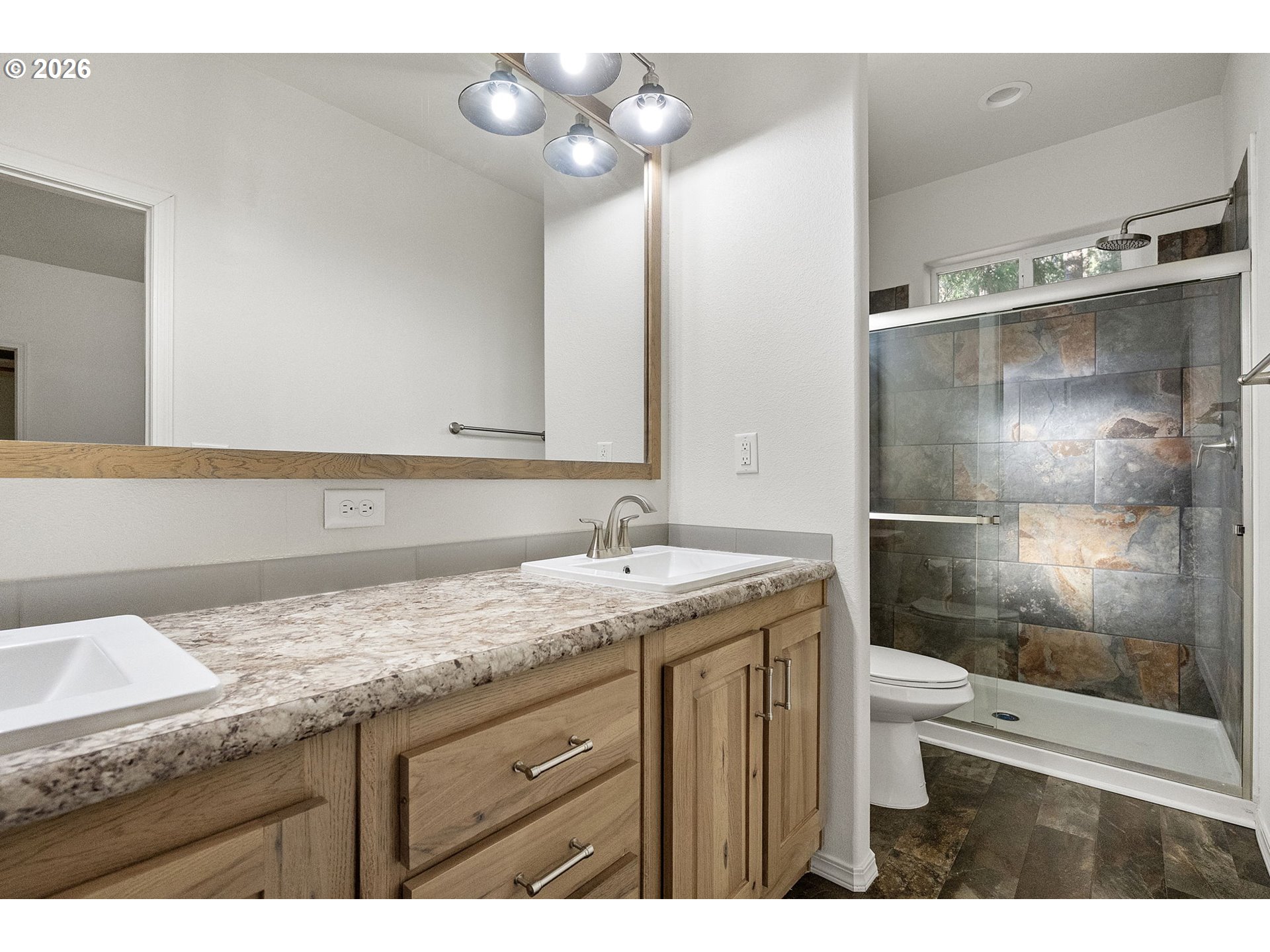 98041 Hallway Road, Unit 19 Brookings, OR 97415 - Photo 11 of 20 a bathroom with a granite countertop sink a toilet and shower