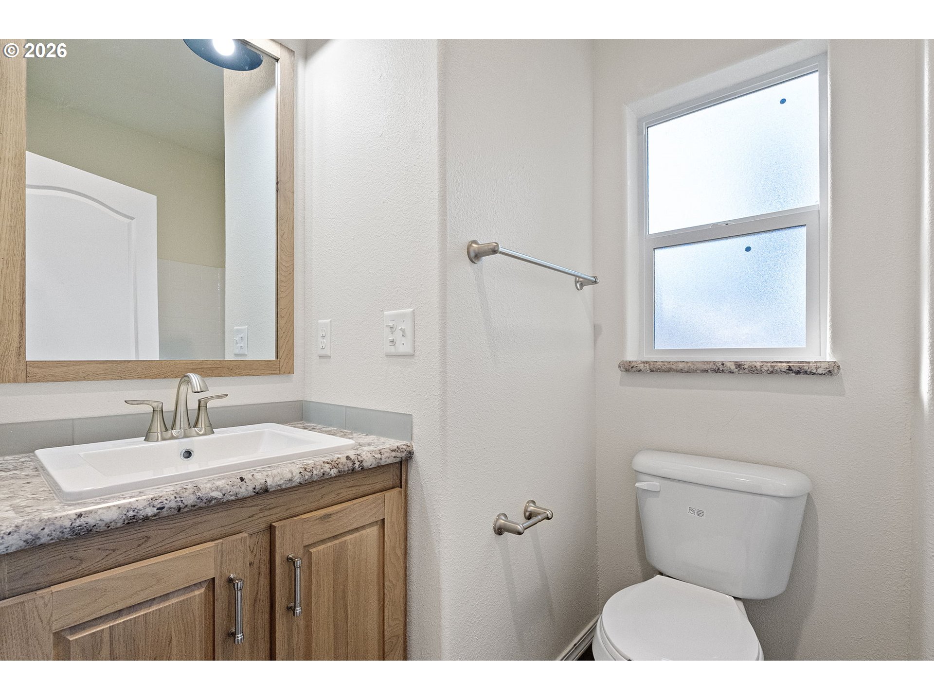 98041 Hallway Road, Unit 19 Brookings, OR 97415 - Photo 14 of 20 a bathroom with a granite countertop toilet sink and mirror
