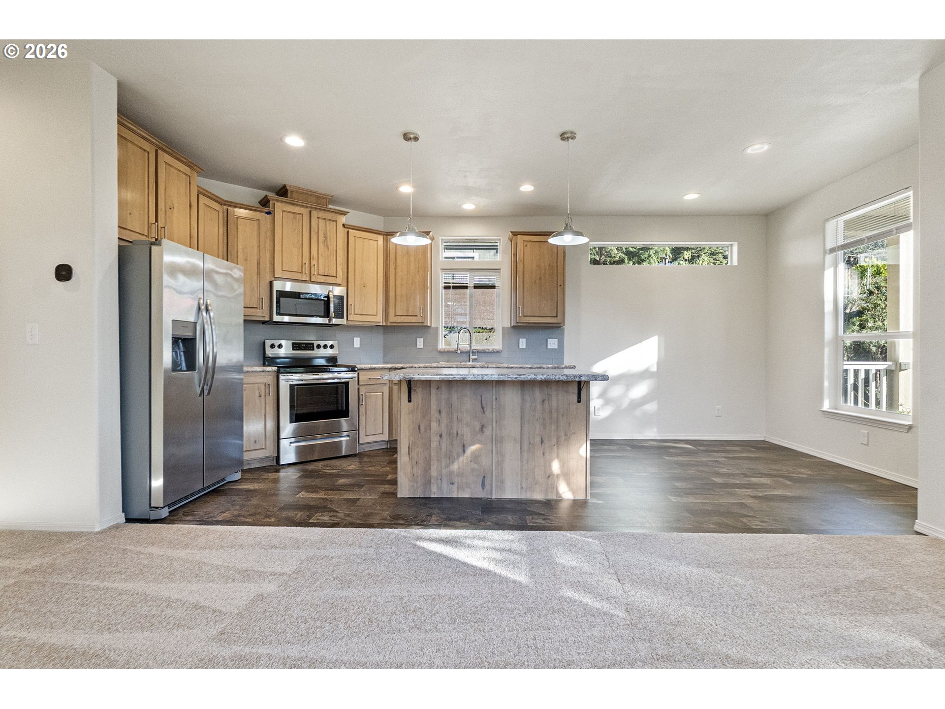 98041 Hallway Road, Unit 19 Brookings, OR 97415 - Photo 4 of 20 a kitchen with kitchen island a counter top space a sink stainless steel appliances and cabinets