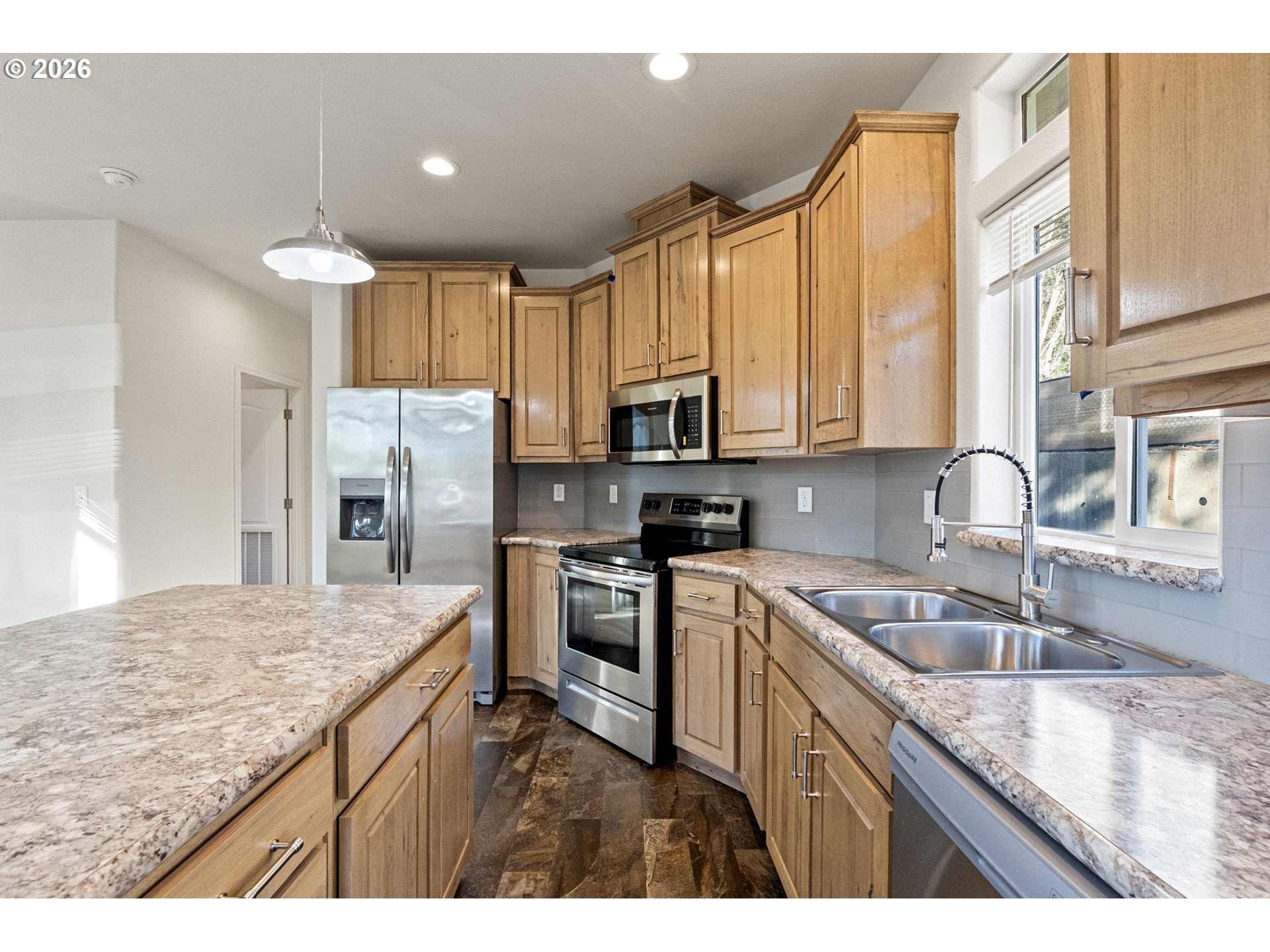 98041 Hallway Road, Unit 19 Brookings, OR 97415 - Photo 5 of 20 a kitchen with kitchen island granite countertop a sink stainless steel appliances and cabinets