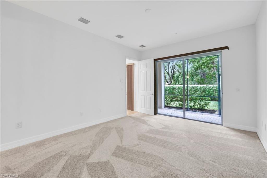 6526 Monterey Point, Unit 101 Naples, FL 34105 - Photo 11 of 20 a view of an empty room with wooden floor and a window