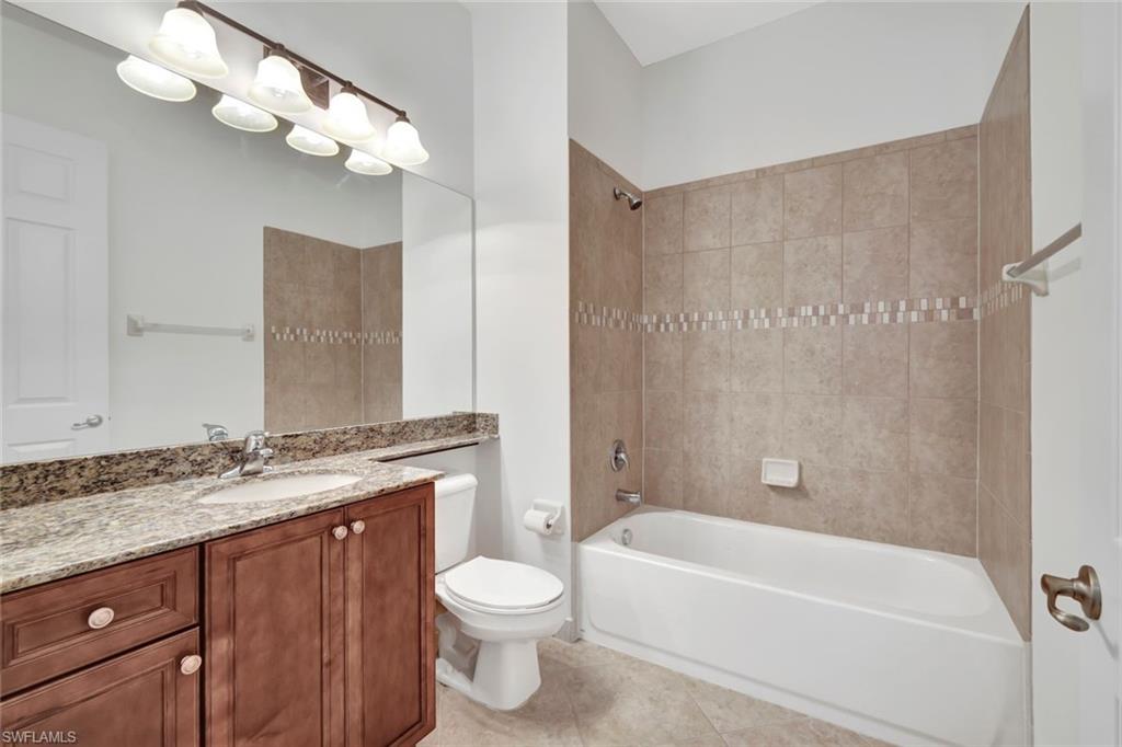 6526 Monterey Point, Unit 101 Naples, FL 34105 - Photo 14 of 20 a bathroom with a granite countertop sink a toilet and bathtub