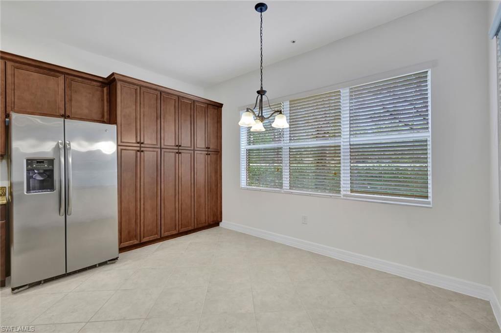 6526 Monterey Point, Unit 101 Naples, FL 34105 - Photo 6 of 20 a view of a kitchen with a refrigerator and a ceiling fan