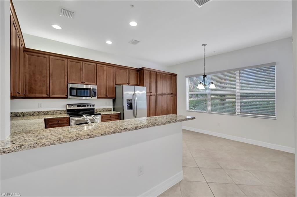 6526 Monterey Point, Unit 101 Naples, FL 34105 - Photo 7 of 20 a large kitchen with stainless steel appliances granite countertop a refrigerator a stove a sink and a granite counter tops