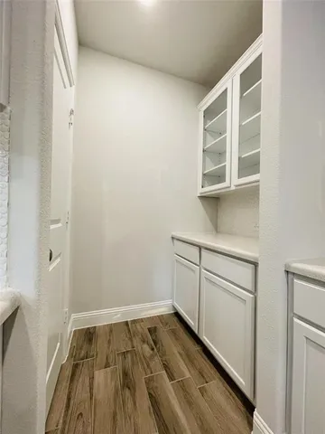 a view of a room with wooden floor and cabinet