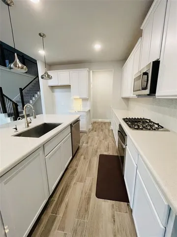 a kitchen with granite countertop a sink stove and cabinets