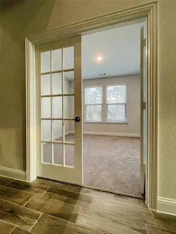 a view of empty room with wooden floor and windows