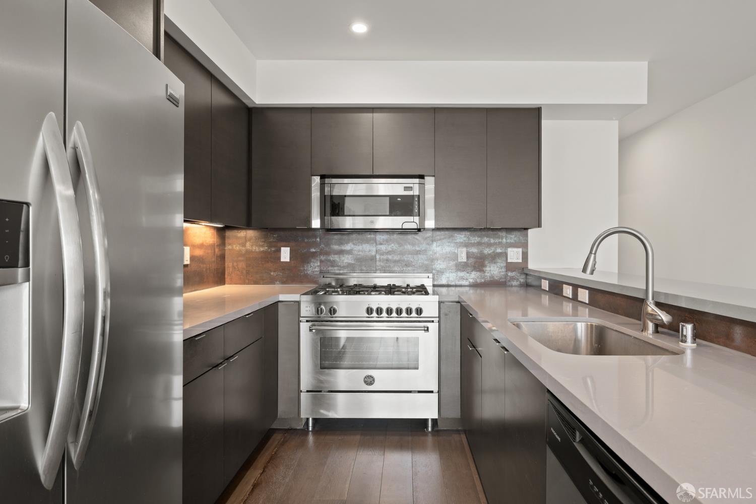 252 9th Street, Unit 503 San Francisco, CA 94103 - Photo 4 of 15 a kitchen with stainless steel appliances granite countertop a sink stove and refrigerator