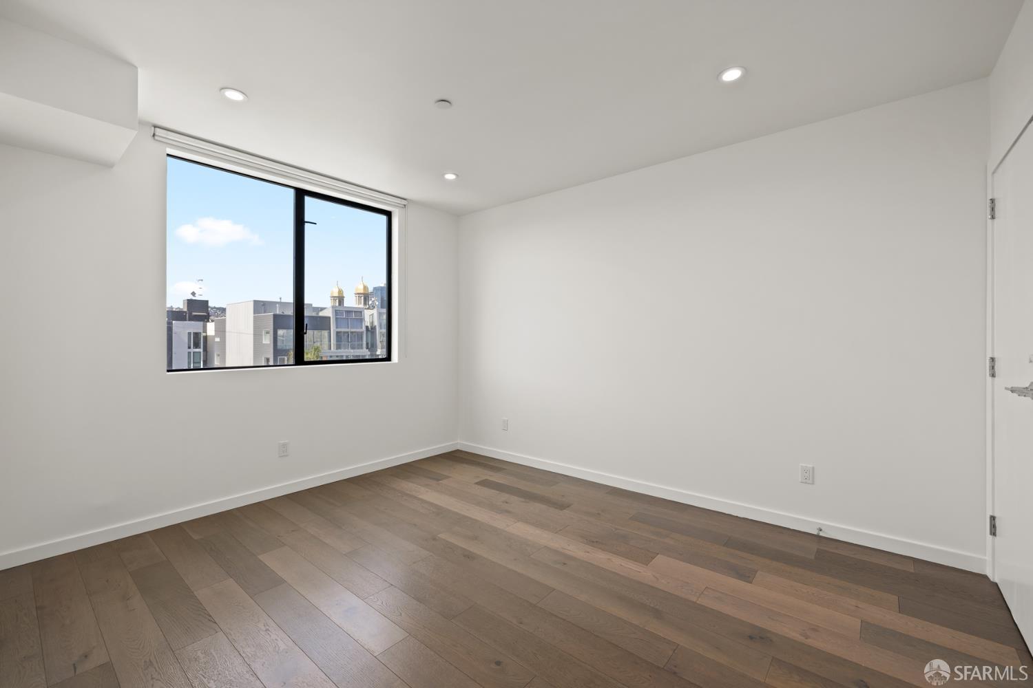 252 9th Street, Unit 503 San Francisco, CA 94103 - Photo 6 of 15 wooden floor in an empty room with a window