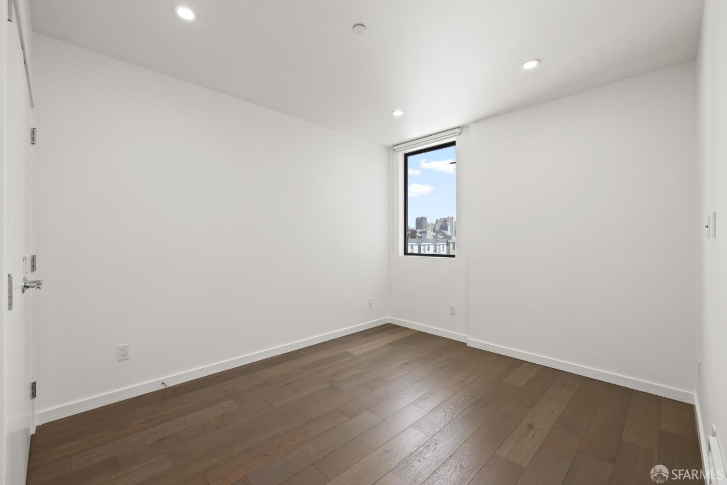 252 9th Street, Unit 503 San Francisco, CA 94103 - Photo 7 of 15 an empty room with wooden floor and white walls