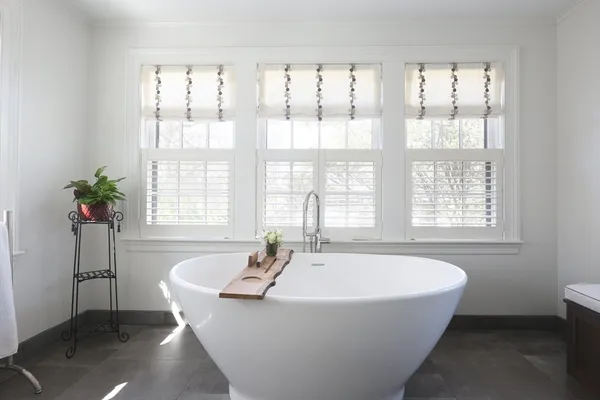 a bedroom with a bed couch and a large window