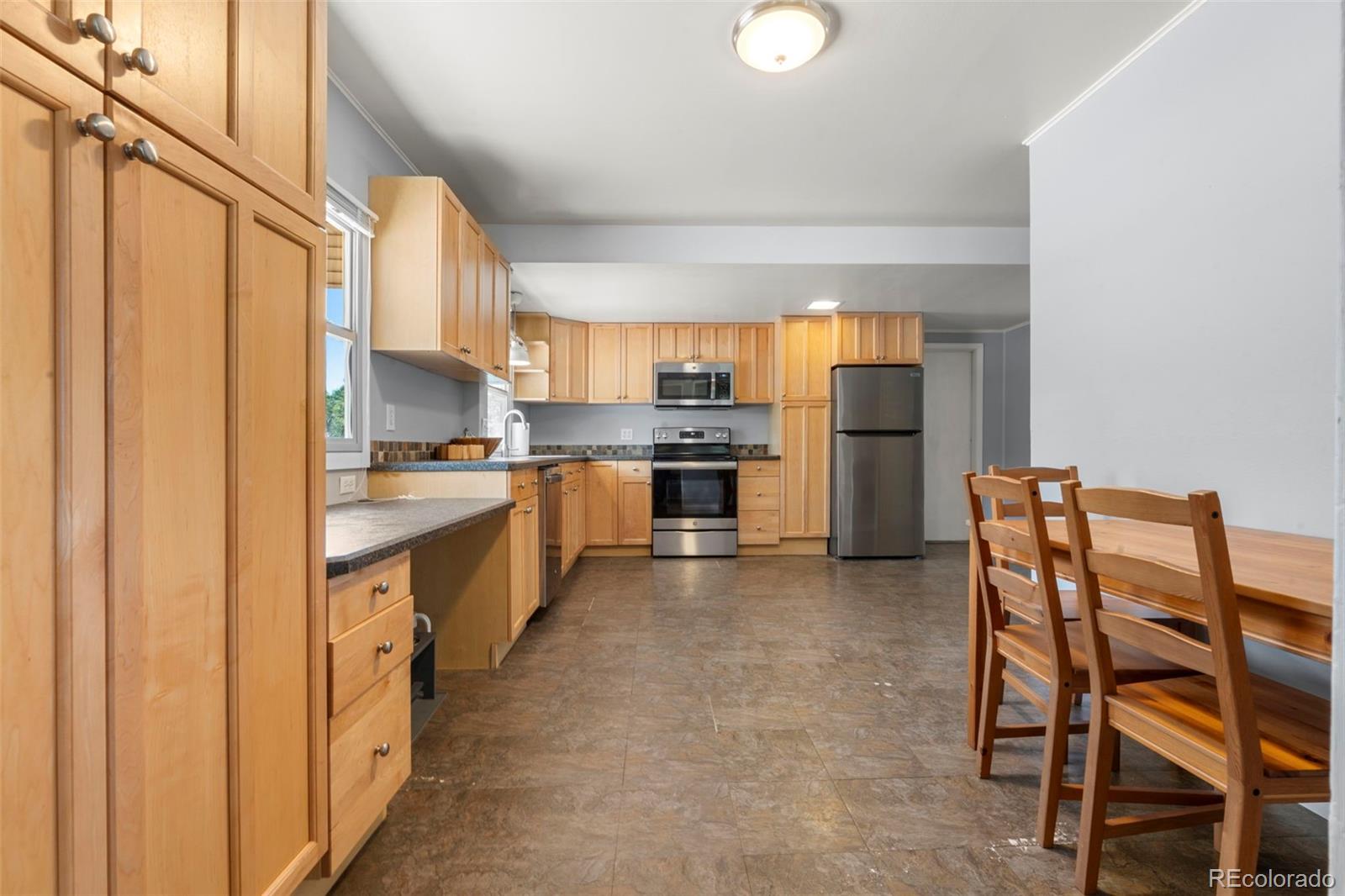 1845 South Mabry Way Denver, CO 80219 - Photo 12 of 20 a kitchen with stainless steel appliances a refrigerator and a stove top oven