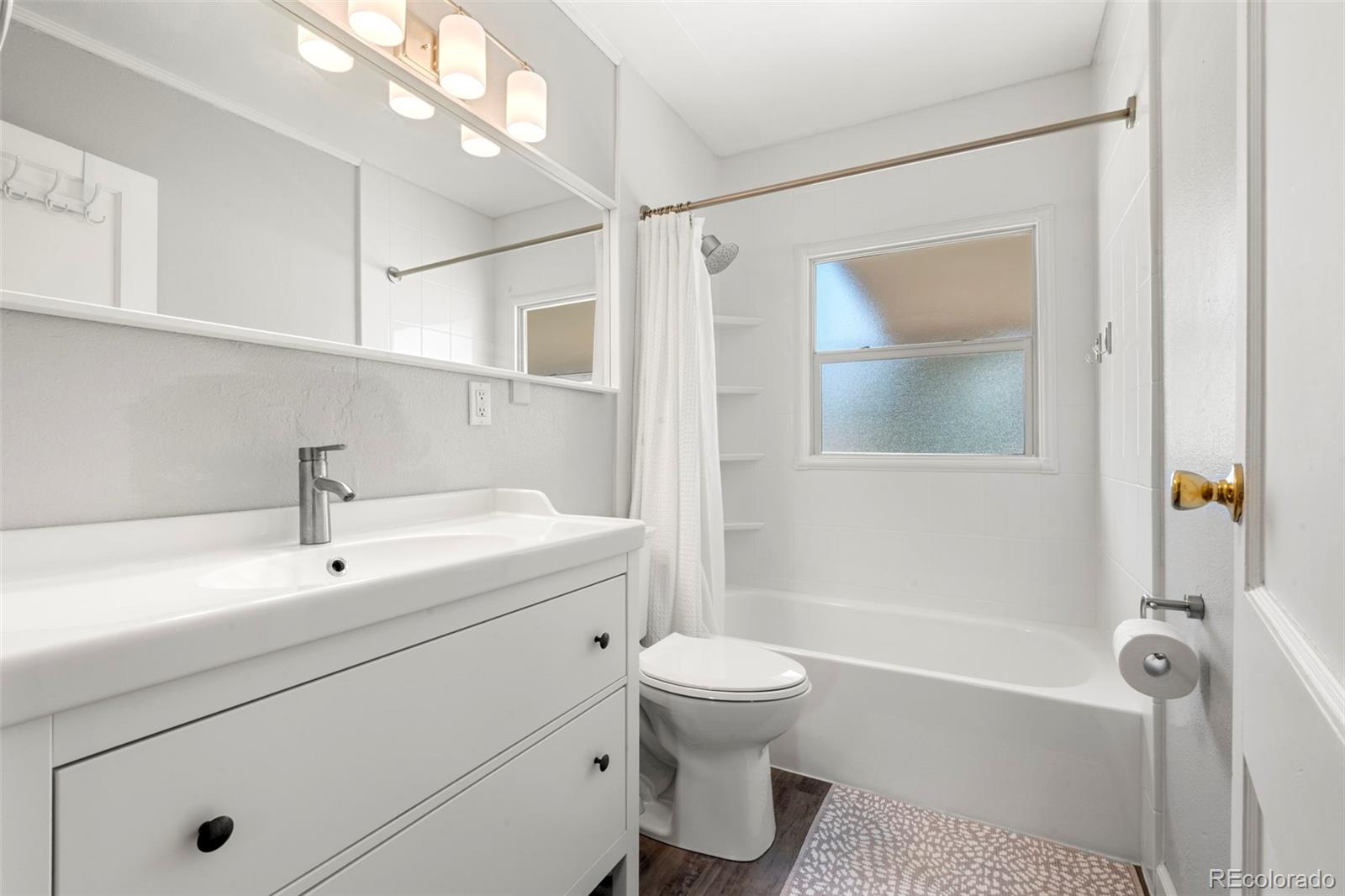 1845 South Mabry Way Denver, CO 80219 - Photo 7 of 20 a bathroom with a sink a toilet and shower