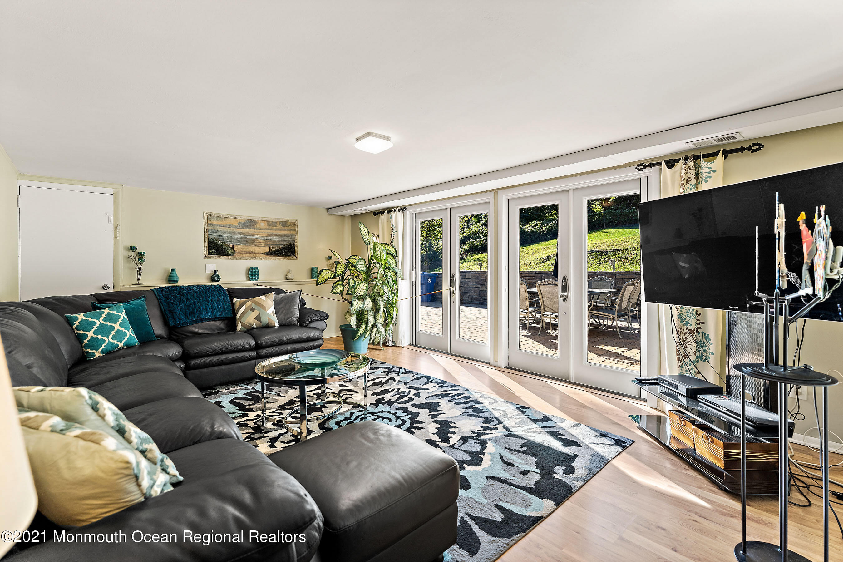 105 Bruce Road Red Bank, NJ 07701 - Photo 17 of 26 a living room with furniture a flat screen tv and a floor to ceiling window