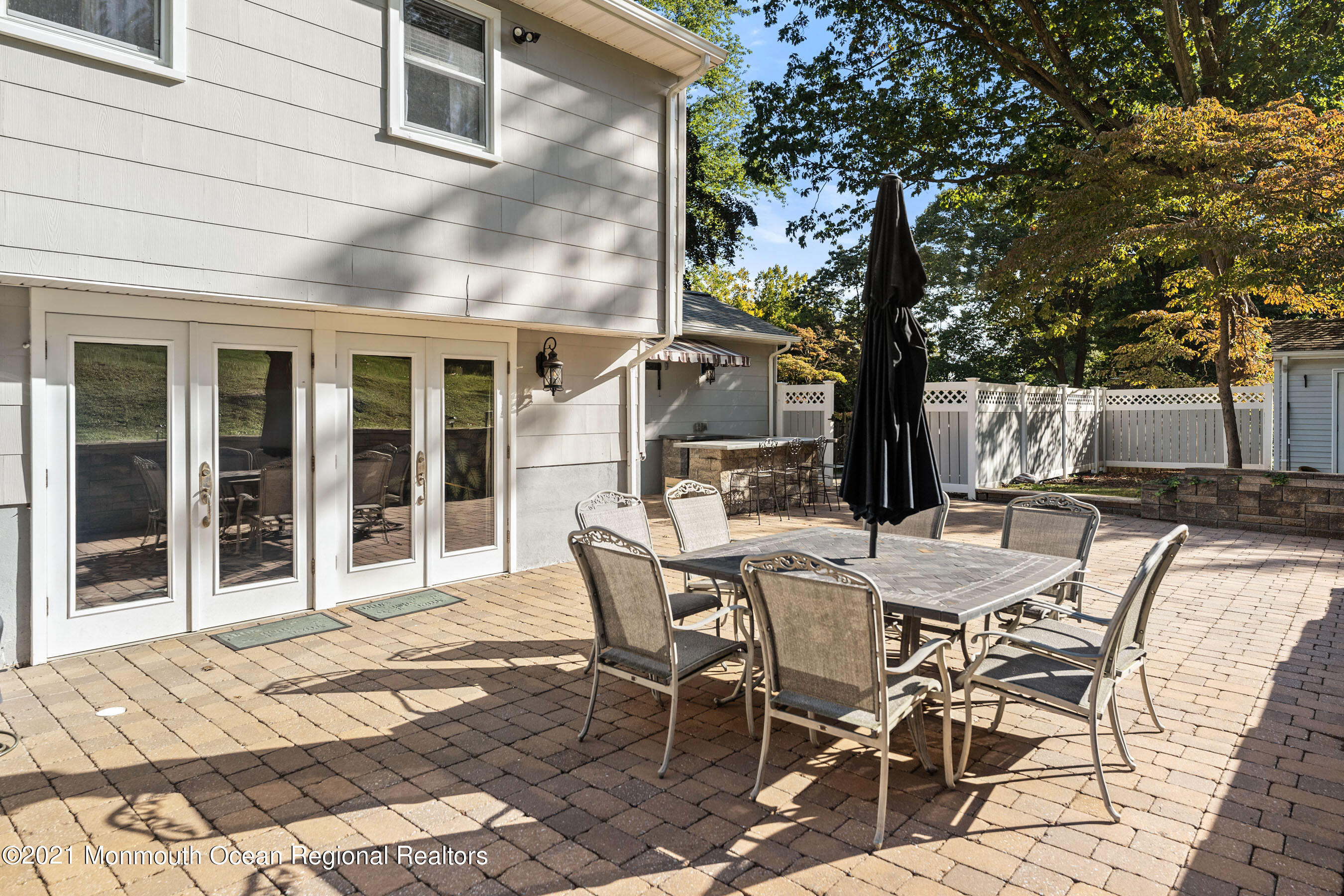 105 Bruce Road Red Bank, NJ 07701 - Photo 20 of 26 a view of a patio with table and chairs with wooden floor and fence