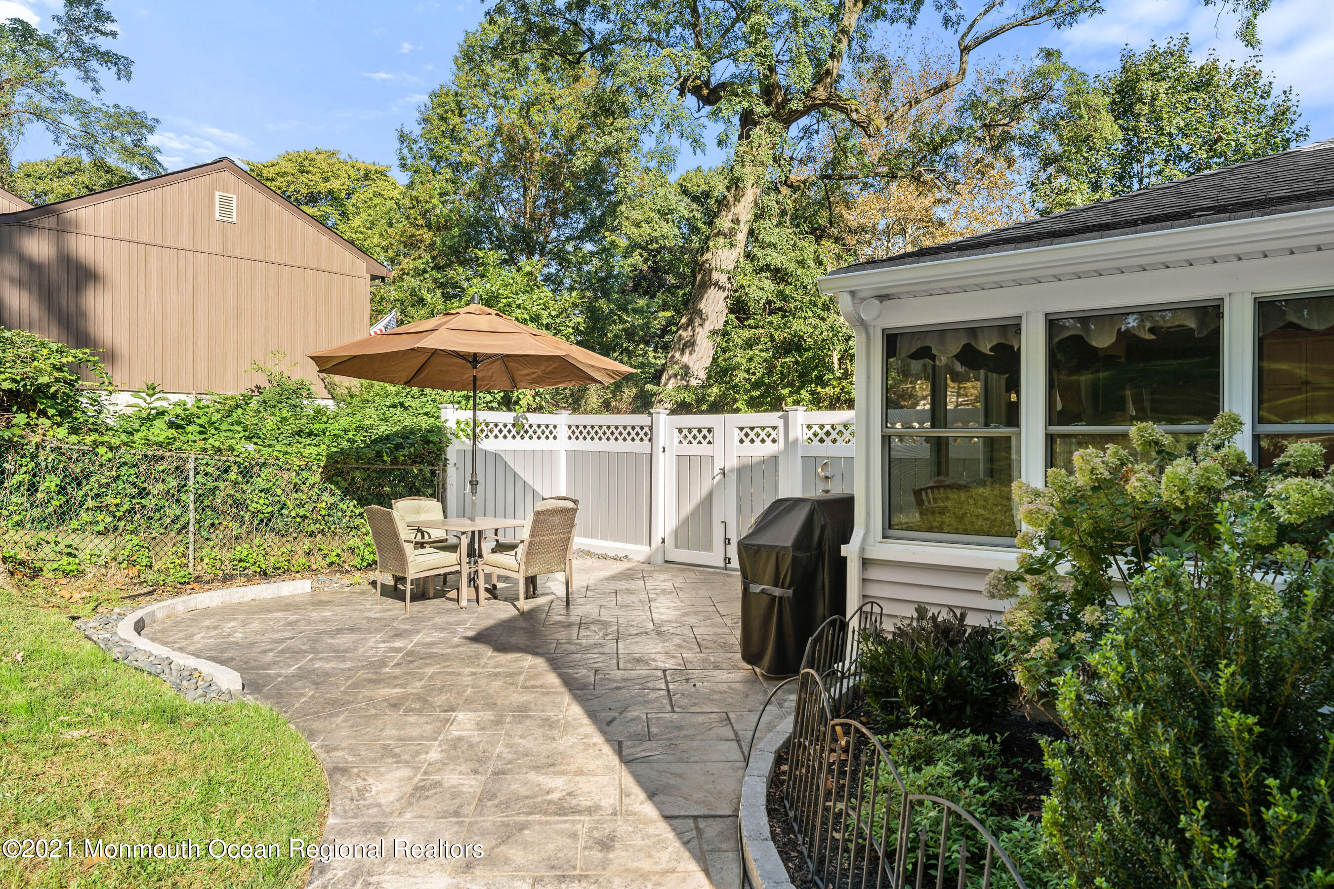 105 Bruce Road Red Bank, NJ 07701 - Photo 23 of 26 a view of a patio with table and chairs under an umbrella