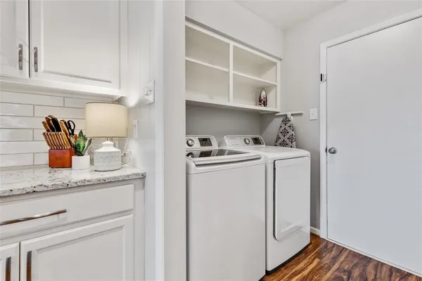 a utility room with cabinets washer and dryer