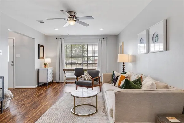 a living room with furniture and a wooden floor