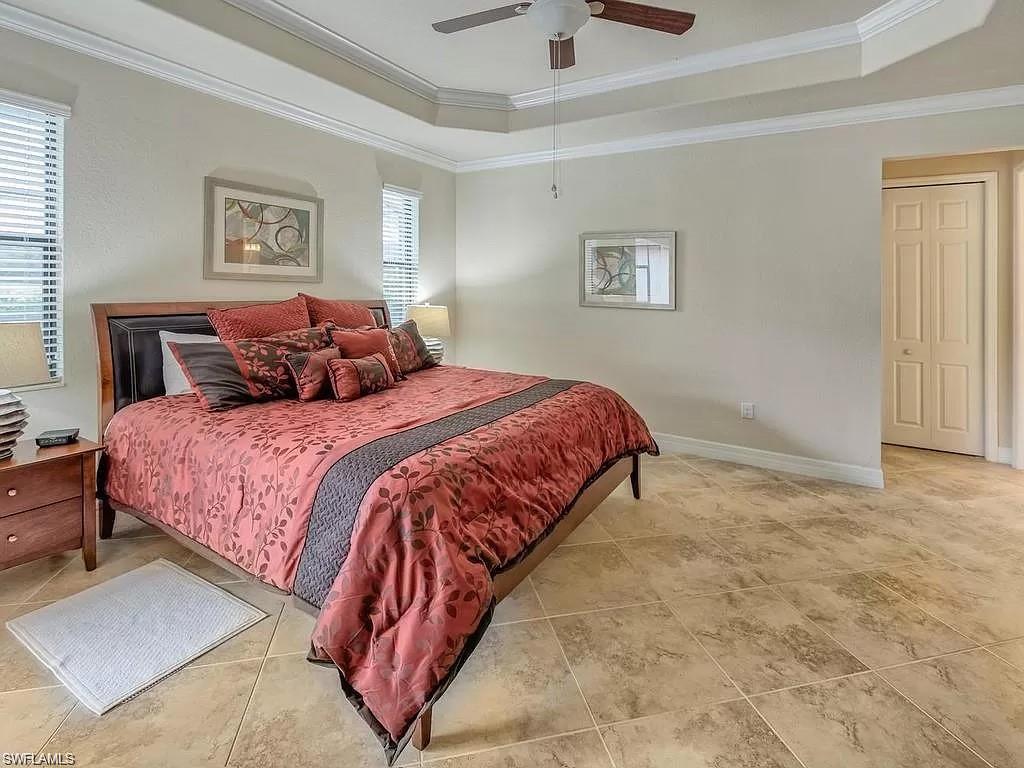 9254 Veneto Place Naples, FL 34113 - Photo 11 of 30 Bedroom with ceiling fan, crown molding, a tray ceiling, and light tile patterned floors