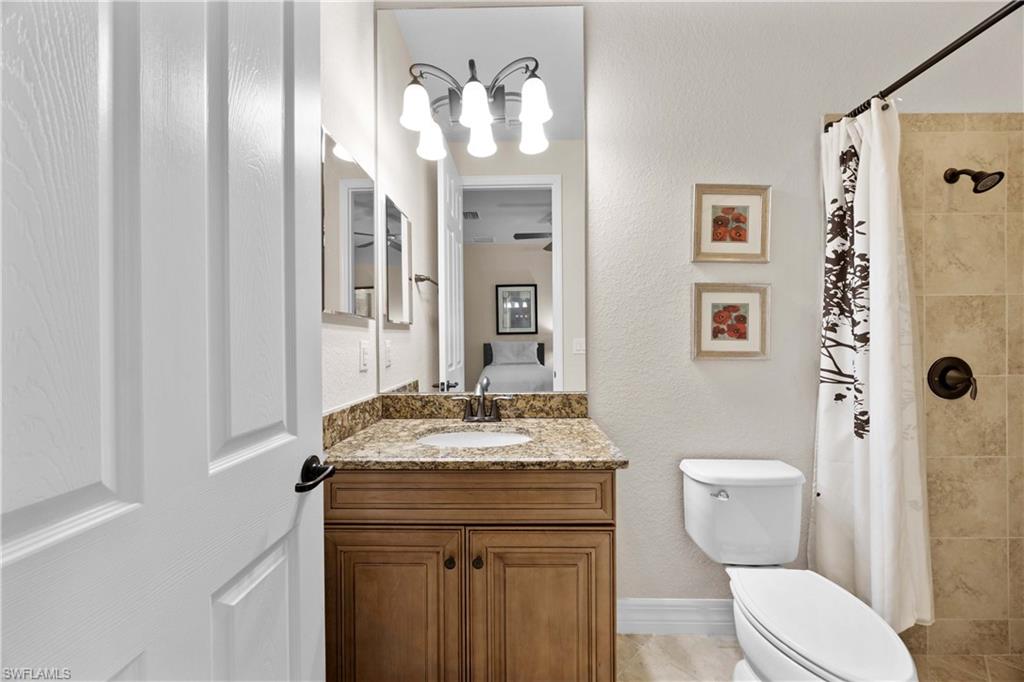 9254 Veneto Place Naples, FL 34113 - Photo 14 of 30 Bathroom with tile floors, vanity, and toilet