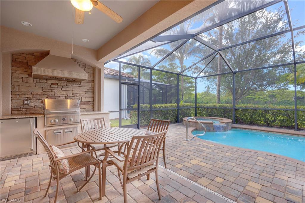 9254 Veneto Place Naples, FL 34113 - Photo 18 of 30 View of pool with ceiling fan, an in ground hot tub, a patio area, a grill, and a lanai