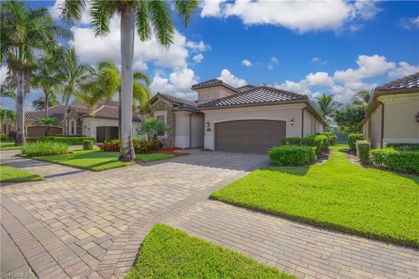 a front view of a house with a yard and potted plants