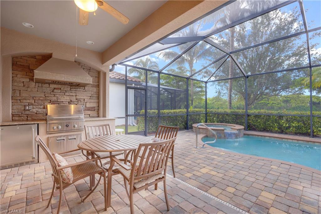 9254 Veneto Place Naples, FL 34113 - Photo 22 of 30 View of swimming pool with ceiling fan, an in ground hot tub, grilling area, a patio area, and glass enclosure