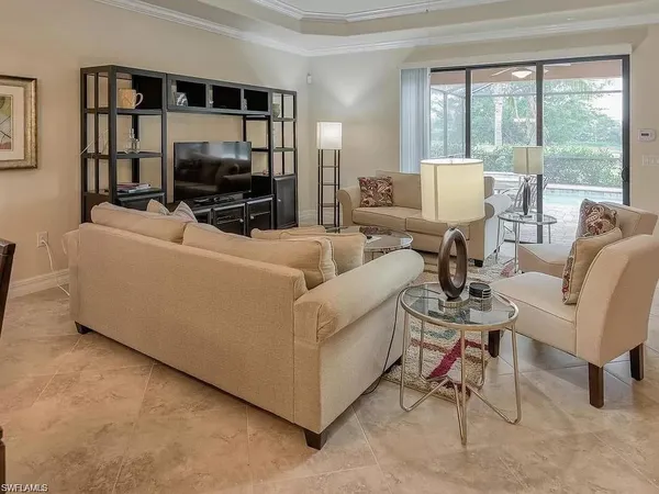 a living room with furniture a flat screen tv and a large window