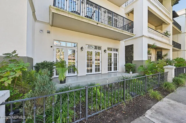 a view of a house with brick walls plants and large windows