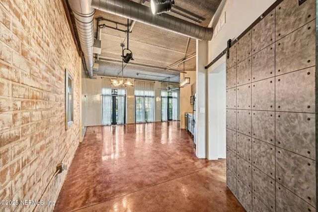 a view of a hallway with wooden floor and door