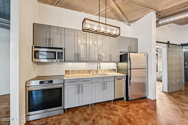 a kitchen with stainless steel appliances a stove microwave and a refrigerator