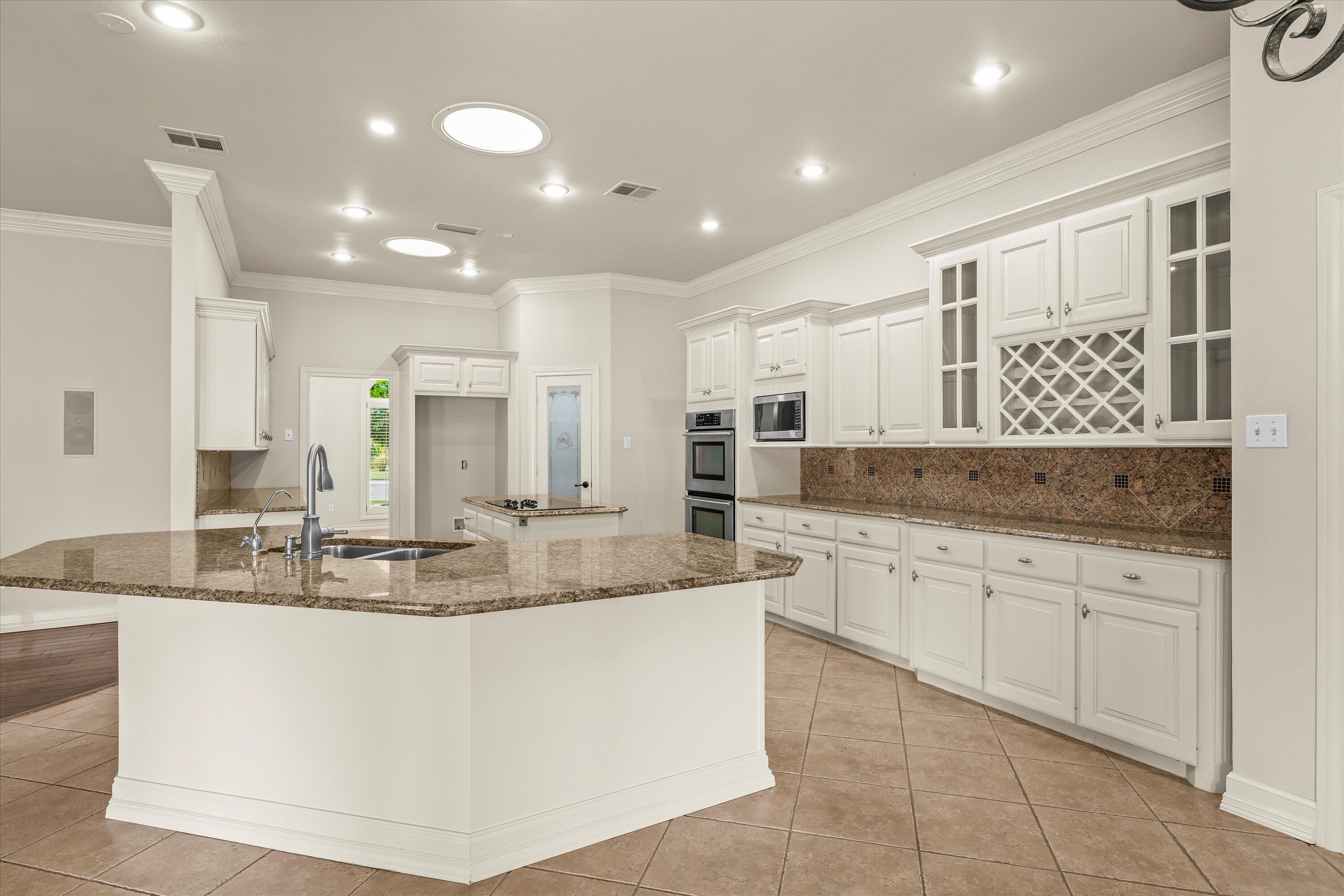5110 96th Street Lubbock, TX 79424 - Photo 11 of 50 a large kitchen with kitchen island a large counter top stainless steel appliances and cabinets