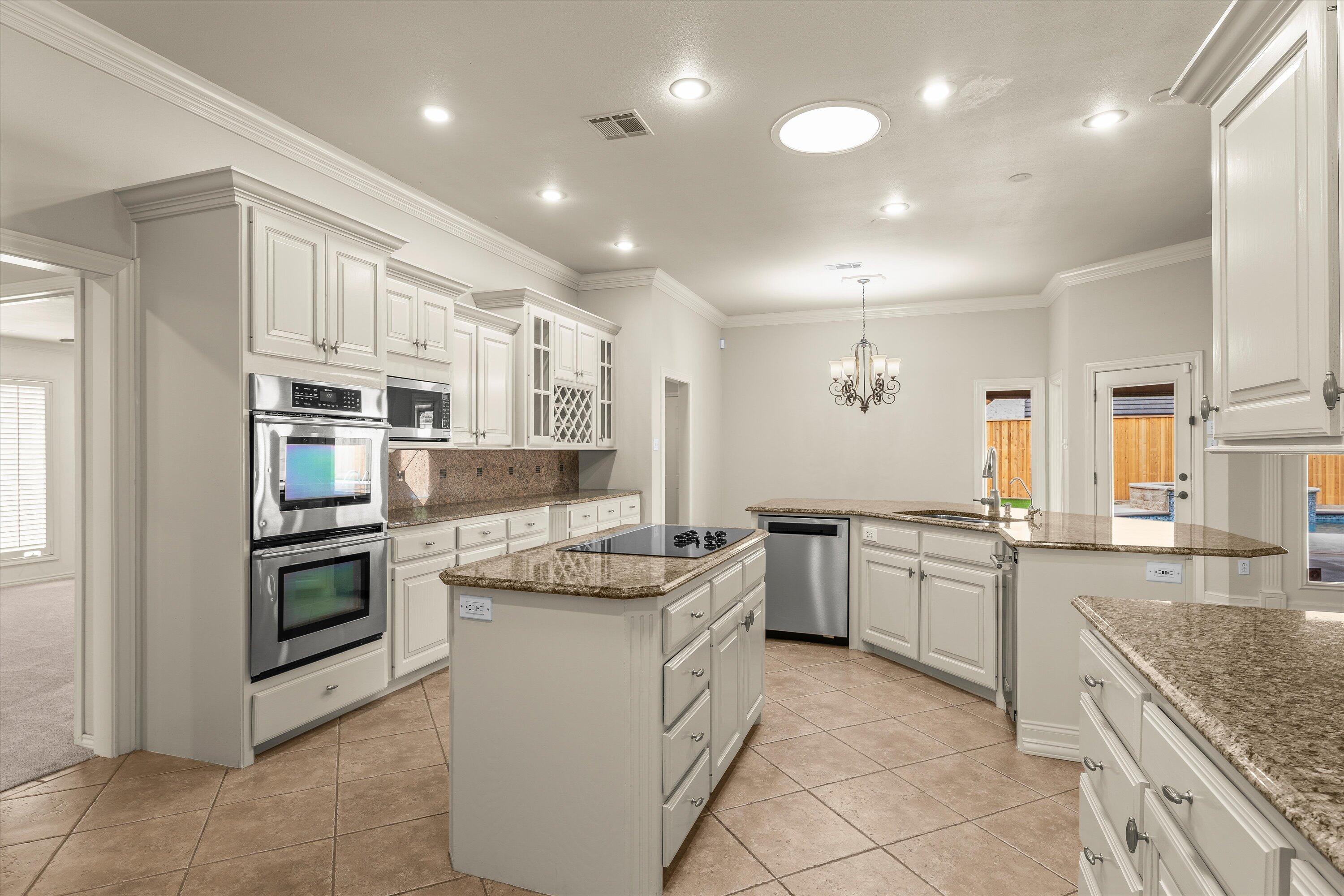 5110 96th Street Lubbock, TX 79424 - Photo 12 of 50 a kitchen with stainless steel appliances granite countertop a stove top oven a sink dishwasher a dining table and chairs with wooden floor