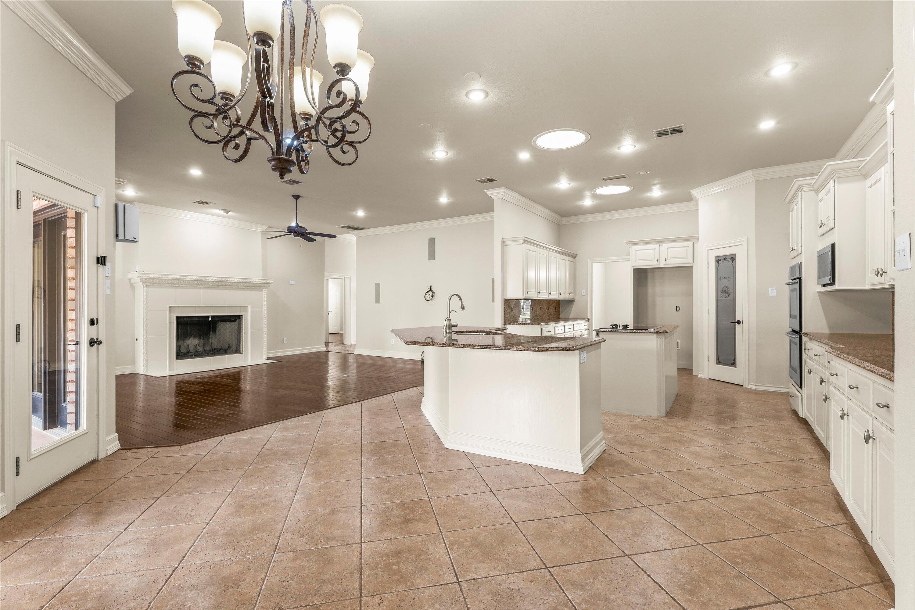 5110 96th Street Lubbock, TX 79424 - Photo 15 of 50 a large kitchen with a refrigerator a stove a sink dishwasher a oven with a dining table and chairs