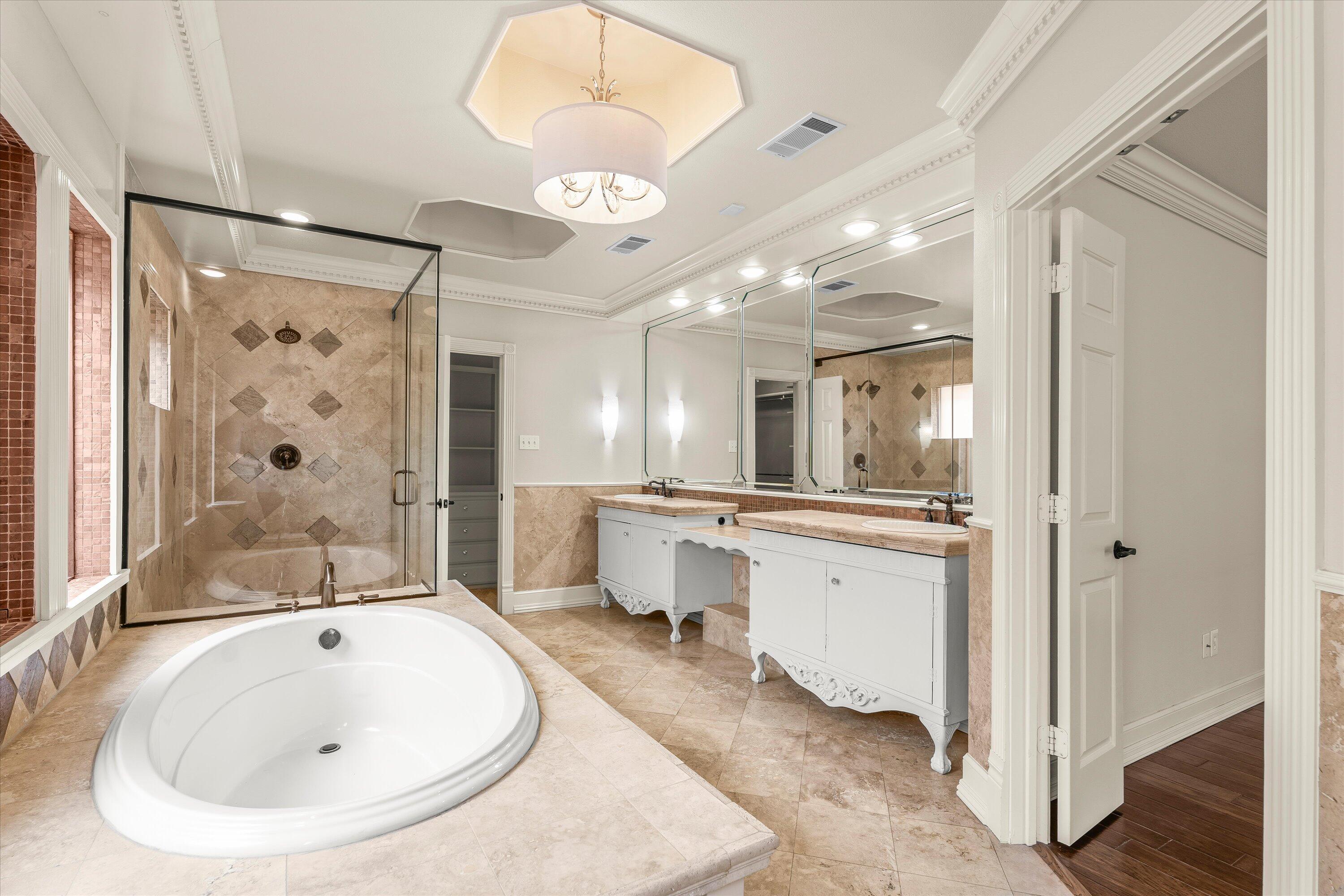 5110 96th Street Lubbock, TX 79424 - Photo 24 of 50 a large bathroom with a tub a sink and a large mirror