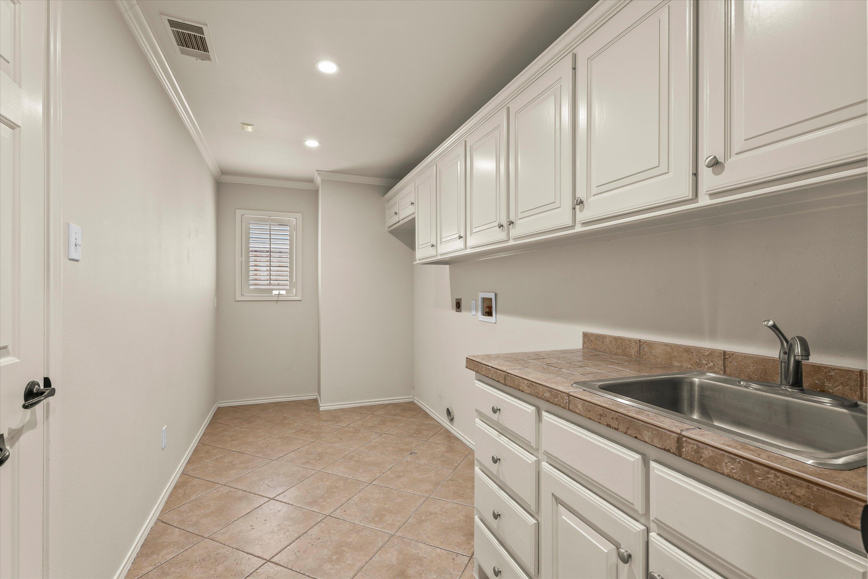 5110 96th Street Lubbock, TX 79424 - Photo 38 of 50 a kitchen with sink cabinets and utility