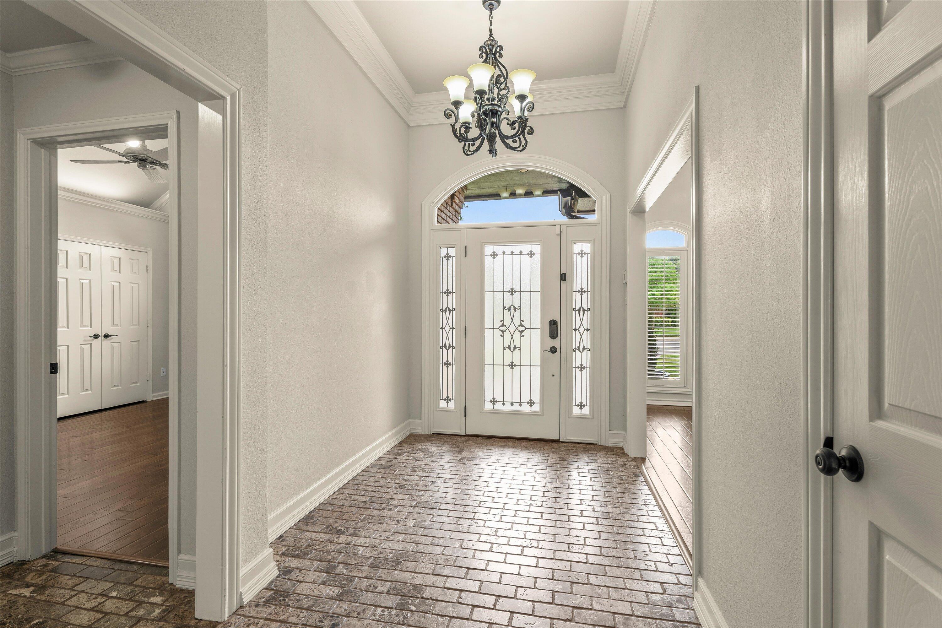 5110 96th Street Lubbock, TX 79424 - Photo 4 of 50 a view of a hallway with wooden floor and a chandelier