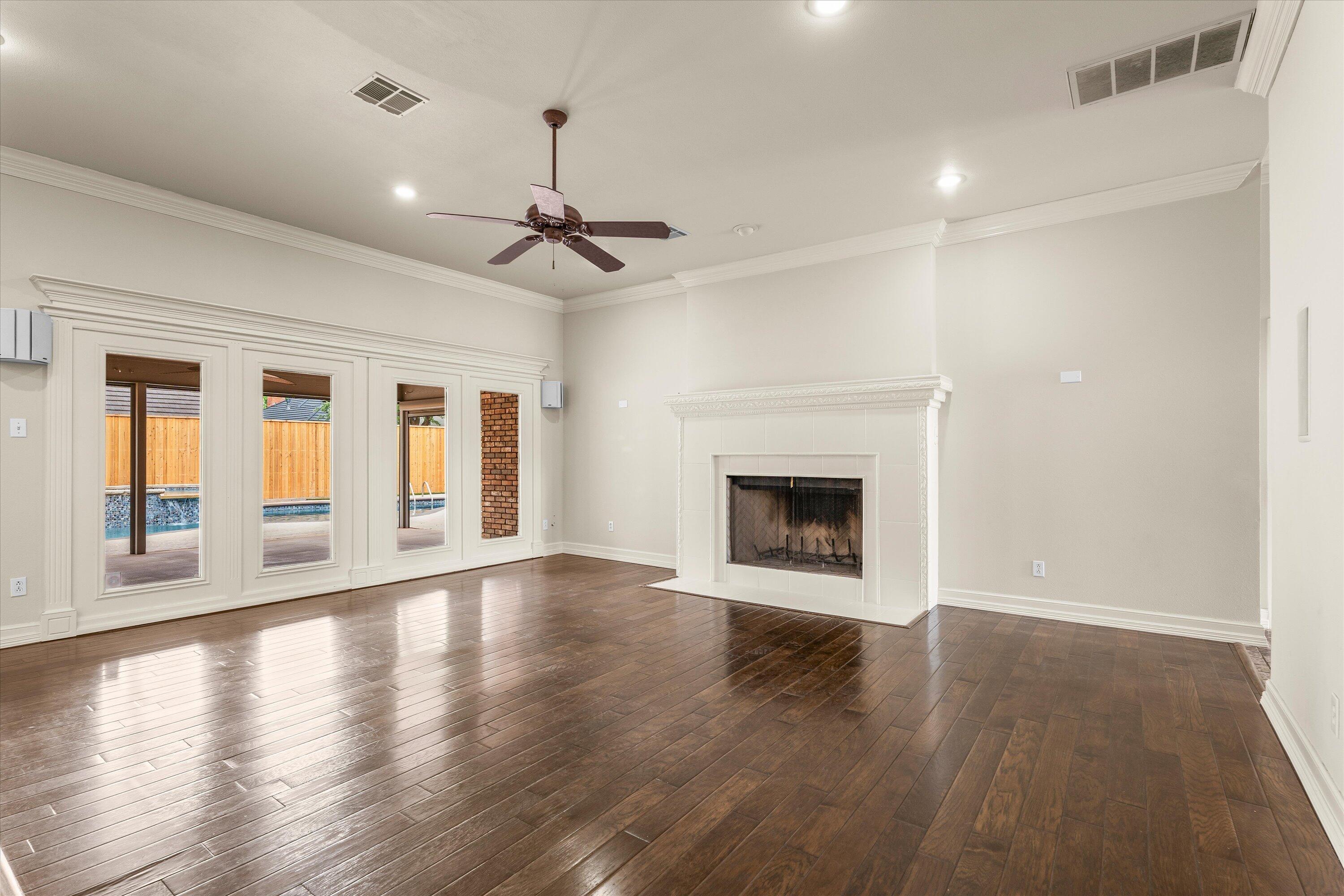 5110 96th Street Lubbock, TX 79424 - Photo 7 of 50 a view of an empty room with wooden floor fireplace and a window
