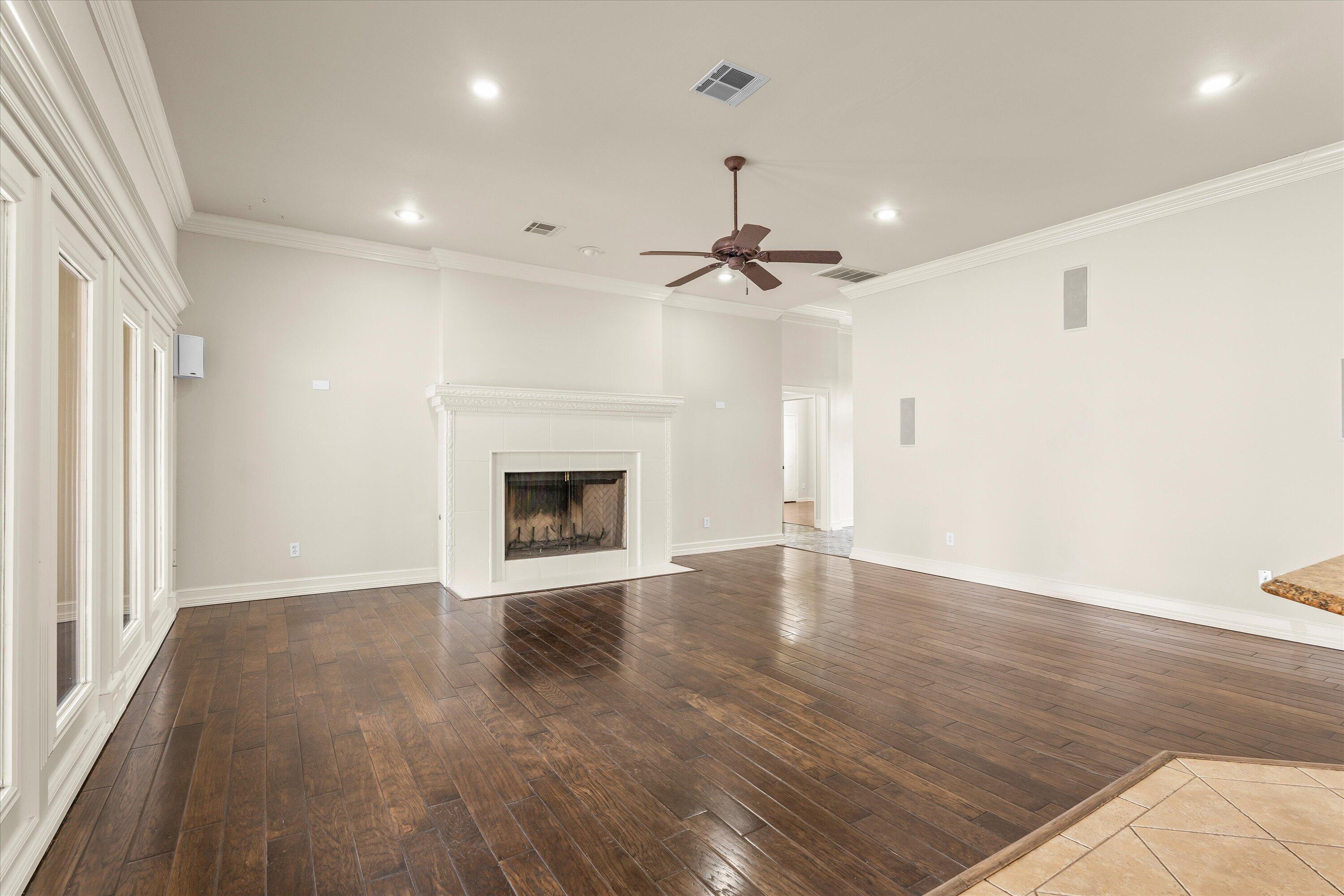 5110 96th Street Lubbock, TX 79424 - Photo 8 of 50 a view of an empty room with wooden floor fireplace and a window