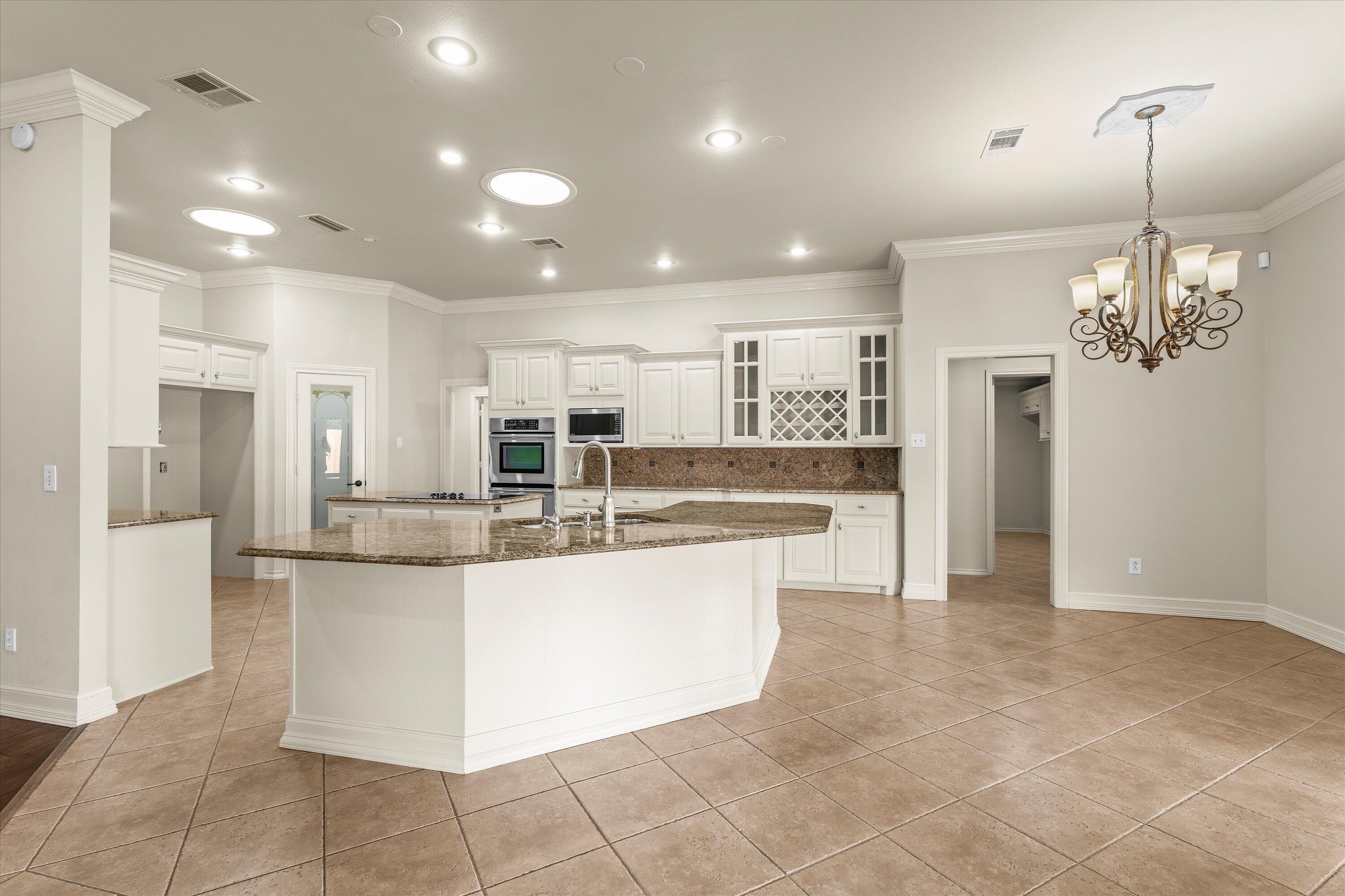 5110 96th Street Lubbock, TX 79424 - Photo 10 of 50 a large kitchen with kitchen island a chandelier and refrigerator