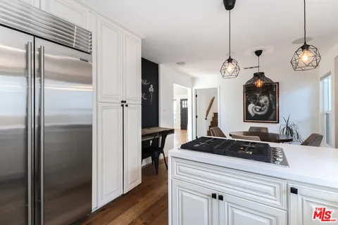a kitchen with a refrigerator a stove and cabinets