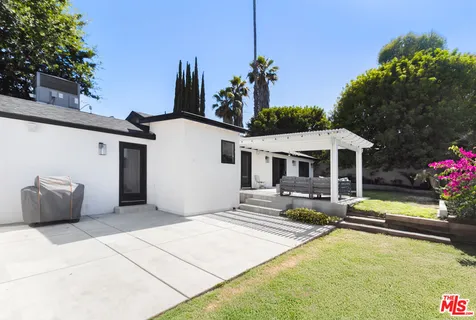a view of a house with swimming pool and sitting area