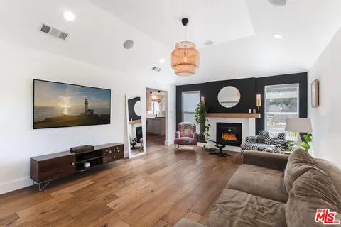 a living room with furniture a fireplace and a flat screen tv