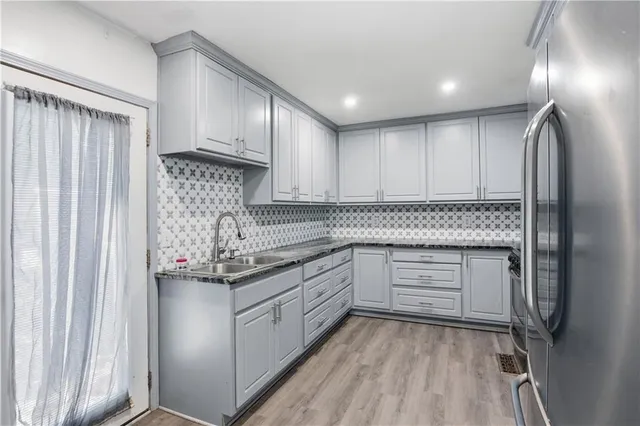 a kitchen with stainless steel appliances granite countertop a stove a sink and a refrigerator with cabinets