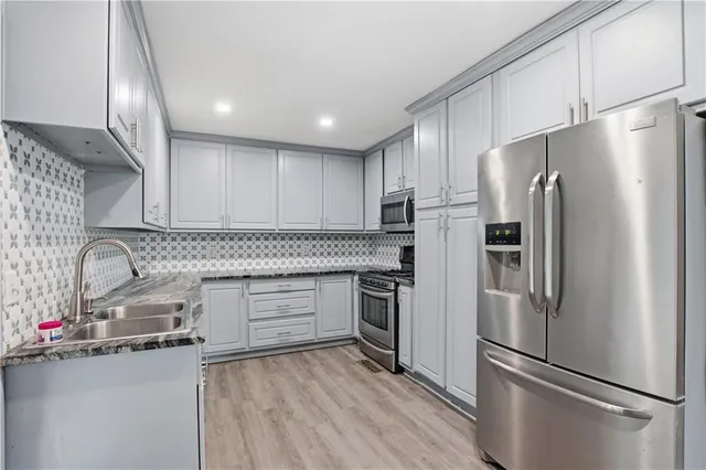 a kitchen with stainless steel appliances a refrigerator sink and cabinets