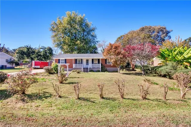 a front view of a house with a yard covered with snow