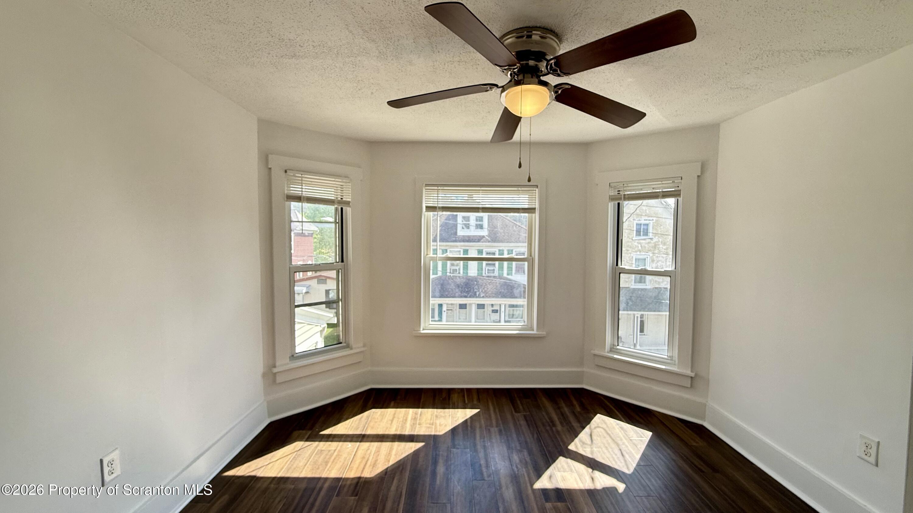 1032 Chestnut Street Sunbury, PA 17801 - Photo 2 of 25 an empty room with wooden floor fan and windows