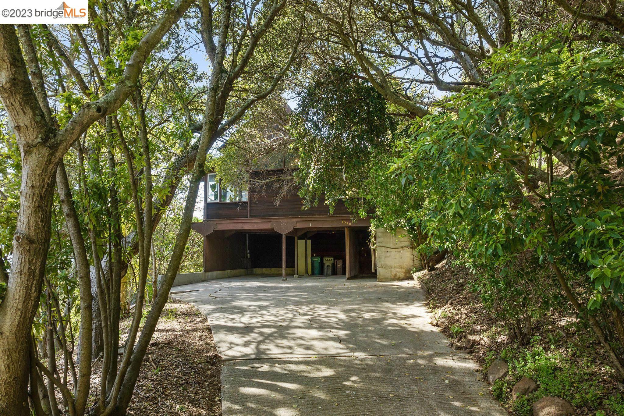 a front view of a house with a tree