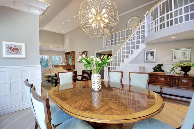 a dining room with furniture a chandelier and wooden floor