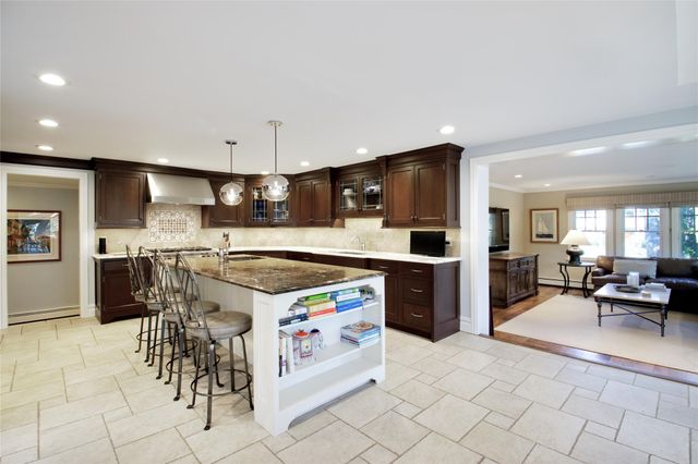 a kitchen with stainless steel appliances kitchen island granite countertop a sink and cabinets